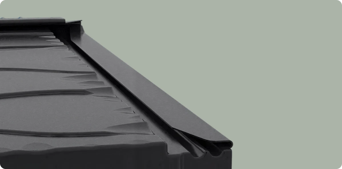 Close-up of a black metal locking system edge for securing panels or sheets.