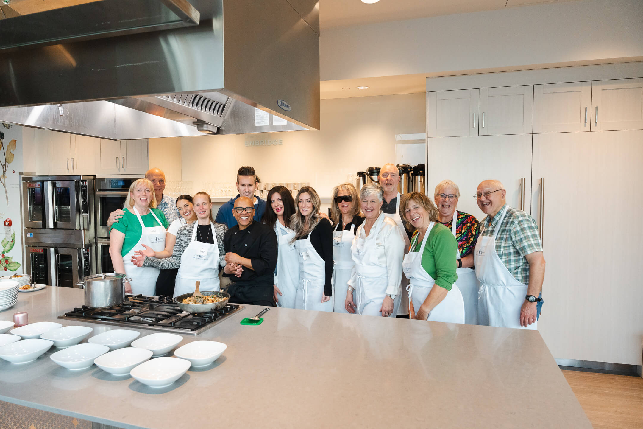 Chef Joey and corporate group posing together after a team cooking class event in Calgary