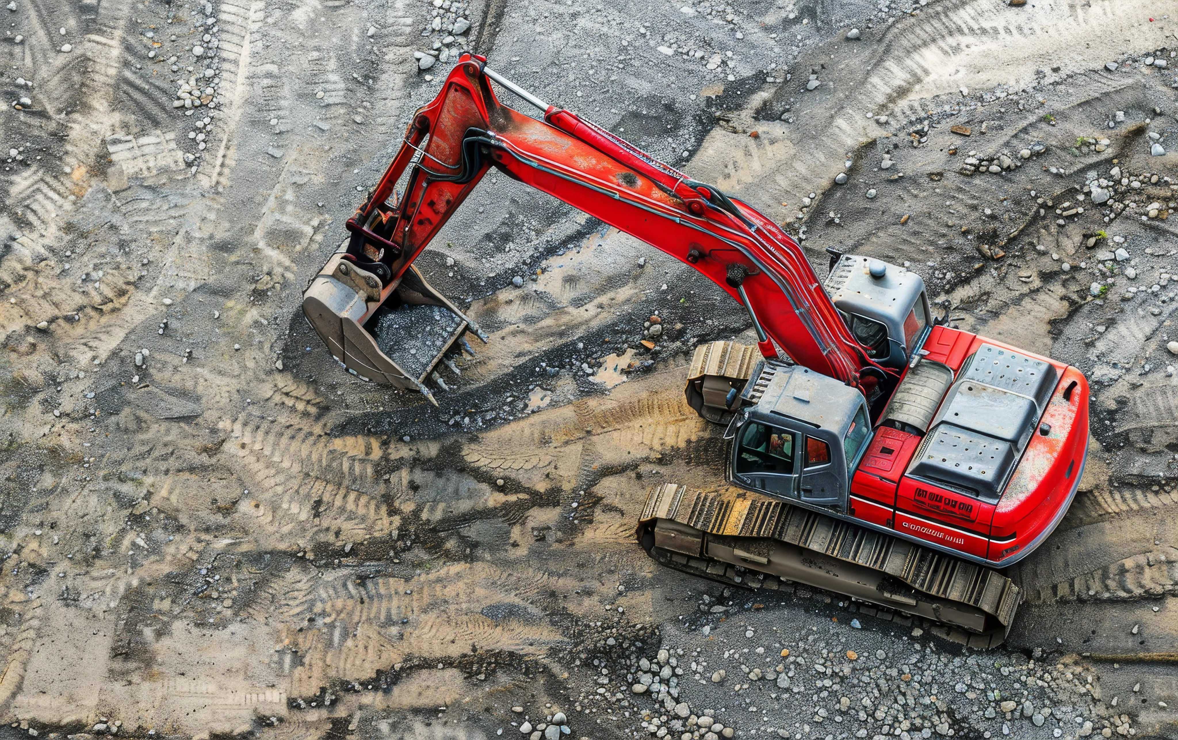 Roter Radlader auf einer Baustelle mit sandigen Boden und Kies im Hintergrund – HZM Baustelleneinsatz