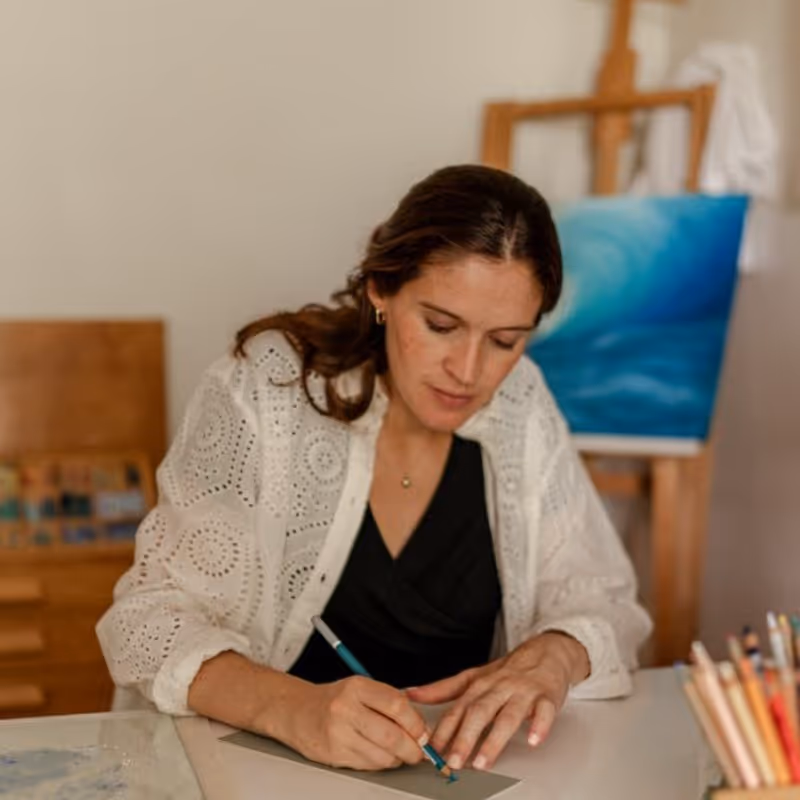 une femme en train de dessiner sur une feuille de papier