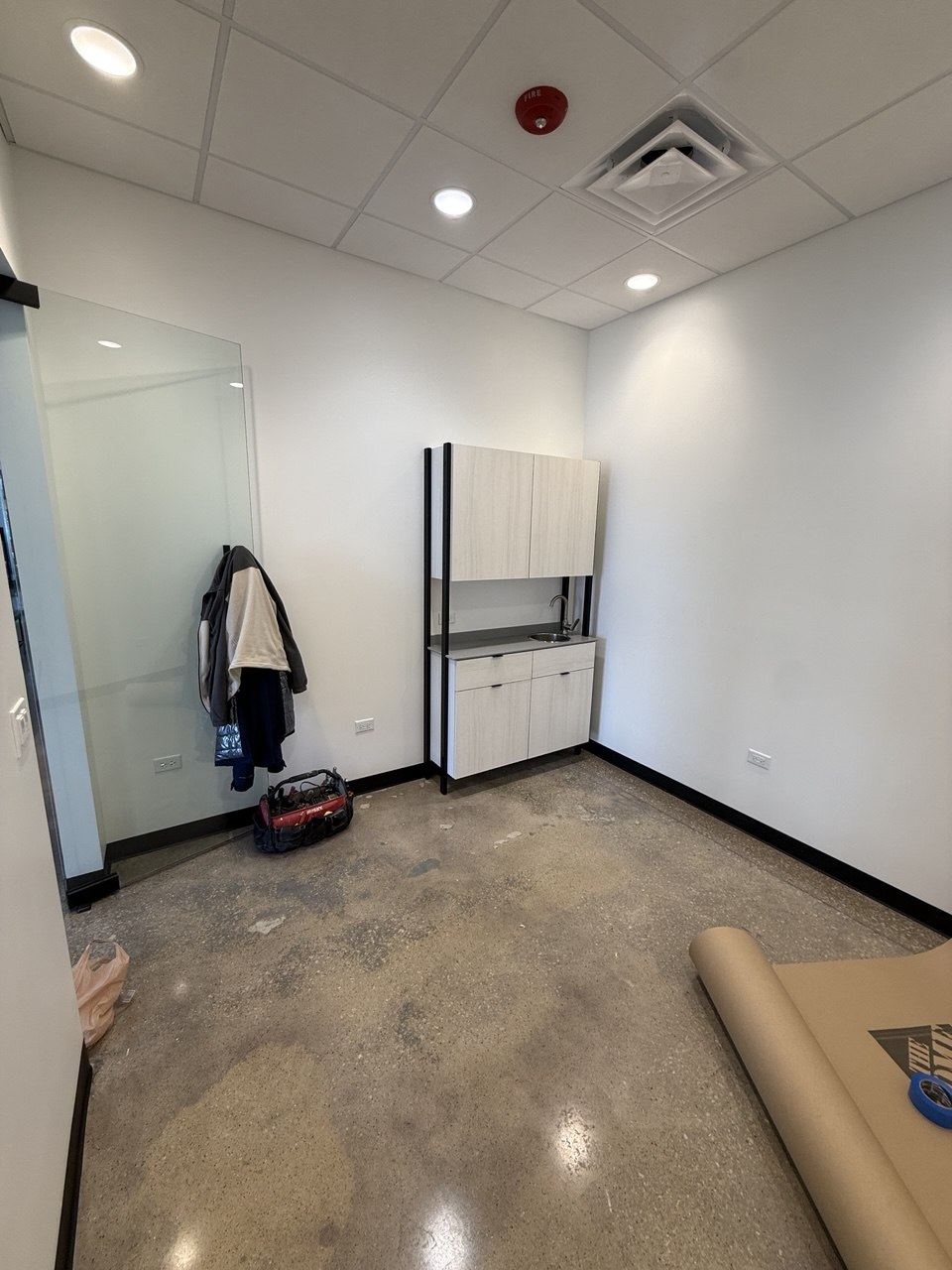 Commercial nail studio setup in progress in Naperville, IL showing cabinet installation, painted walls, and preparation for manicure workstation setup