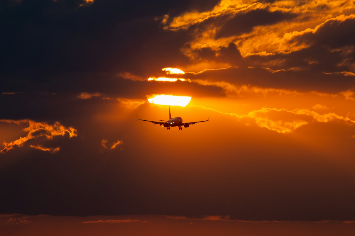 Plane silhouetted against the setting sun