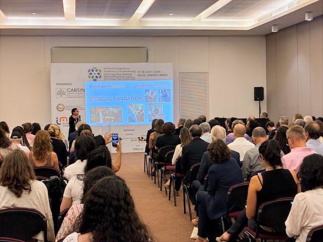 Dr. Michelle Loy speaking to a packed audience at a conference in Brazil