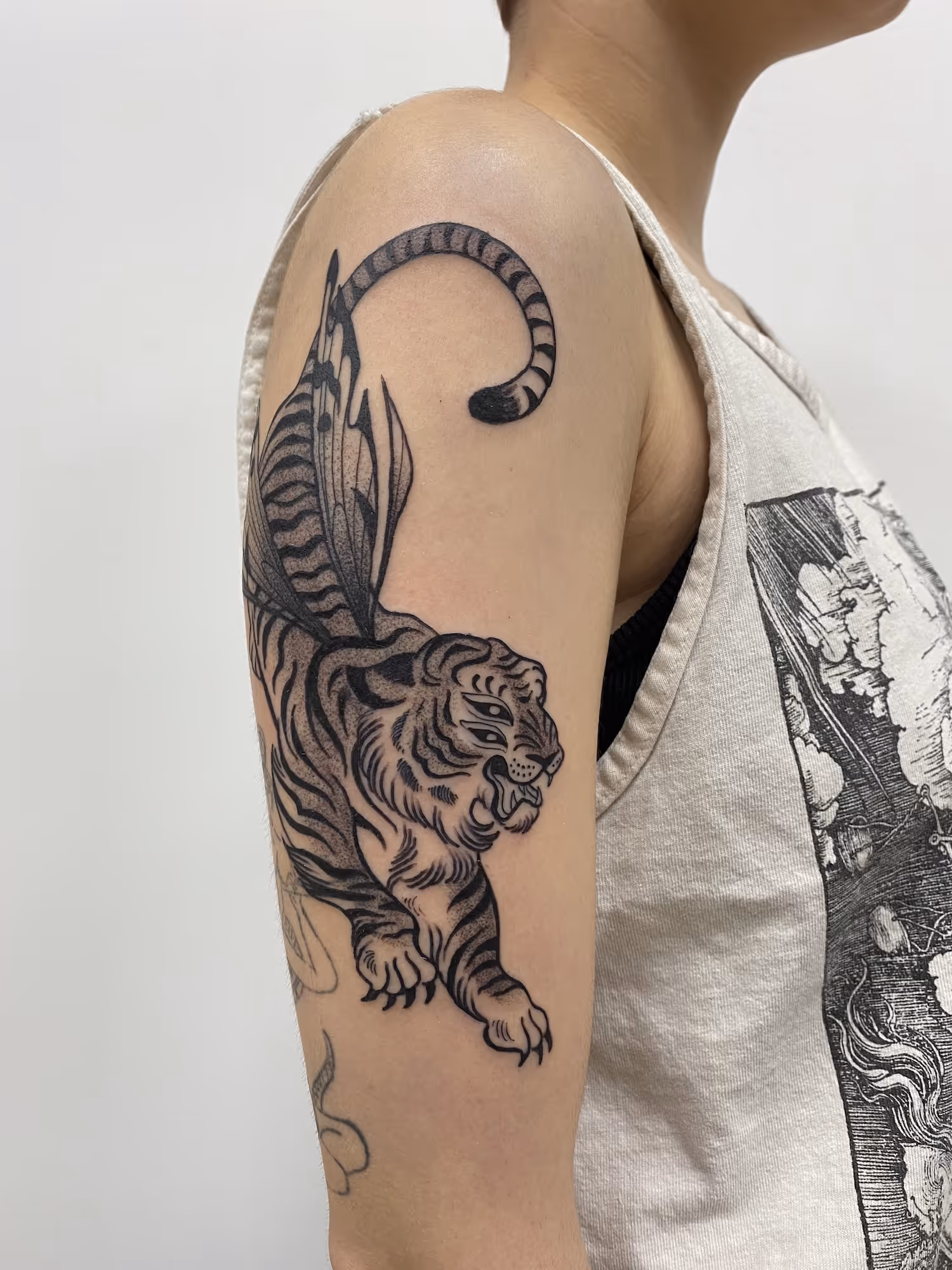 Blackwork upper arm tattoo of a winged tiger, by Alyssa at Vale of the Fae in Castlegar, BC