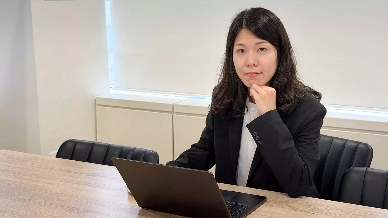 A professional at a laptop contemplating effective implementation strategies for AI demand forecasting.