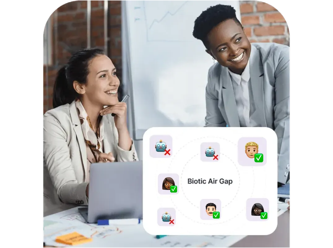 Two women smiling and discussing with a laptop, next to a graphic labeled 'Biotic Air Gap' showing human and robot emojis with check and cross marks.