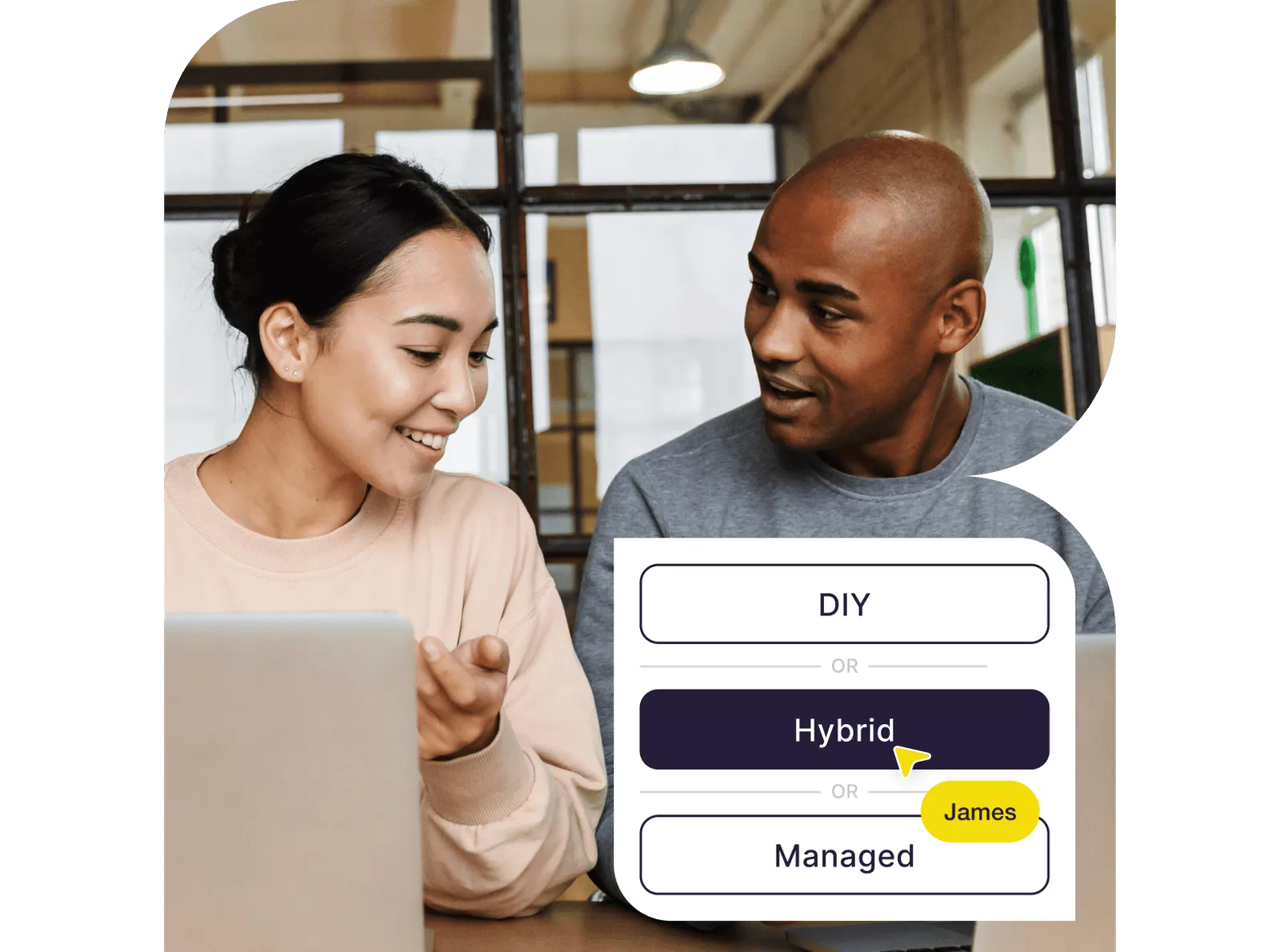 Smiling man and woman sitting at a table with laptops, with a selection box showing options DIY, Hybrid, and Managed, and a yellow cursor pointing at Hybrid.