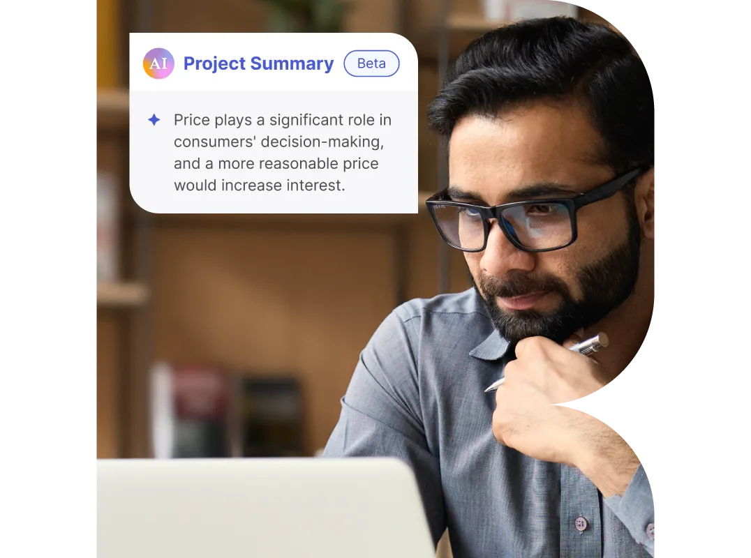 Man wearing glasses working on a laptop with an AI Project Summary note about pricing and consumer decision-making displayed.