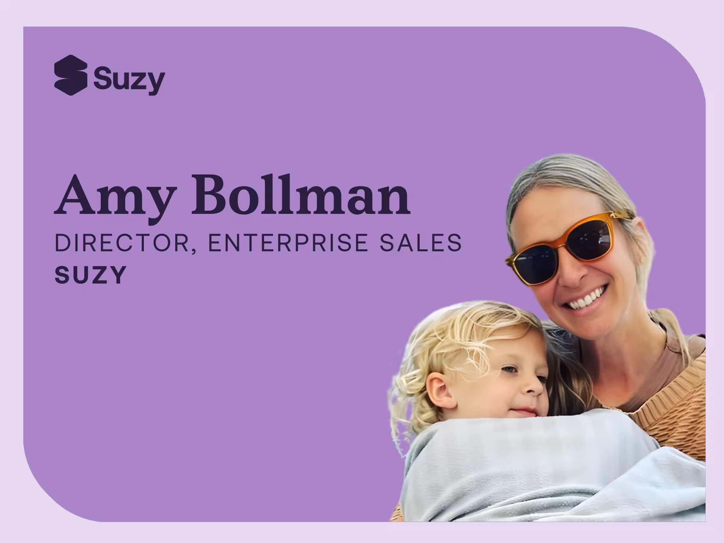 Amy Bollman, Director of Enterprise Sales at Suzy, smiling while holding a young child, shown on a branded Suzy graphic background.