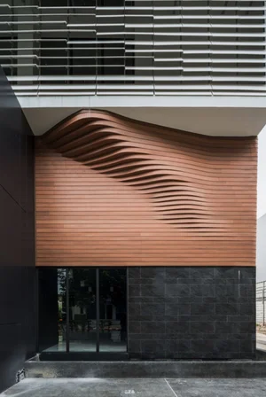 Rippling timber slat facade above a dark stone base