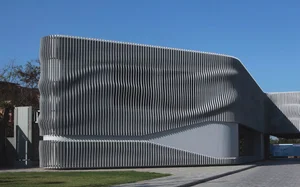 Low building wrapped in a wave-form aluminium fin facade
