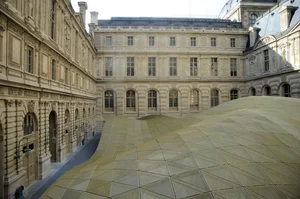 Golden faceted glass roof spanning a historic stone courtyard
