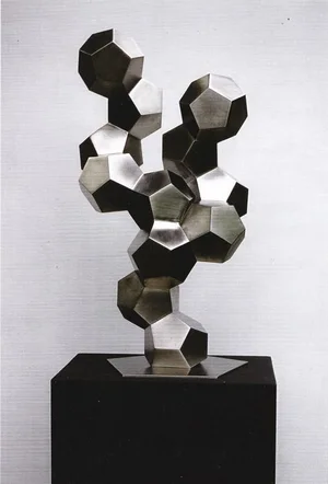 Metal dodecahedron cluster sculpture mounted on a black plinth