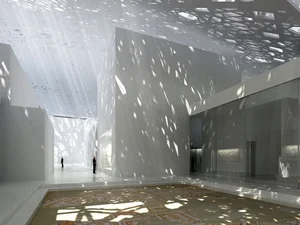 White interior washed with dappled light falling through a perforated dome