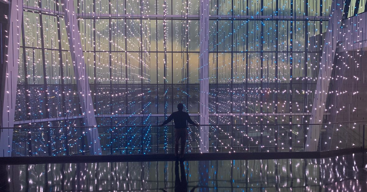 A visitor watching the Virtual Sky installation from the balcony walkway