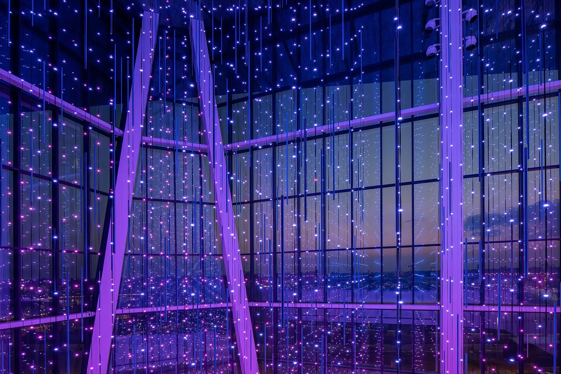 The Virtual Sky LED strand curtain lit violet against the full-height window wall