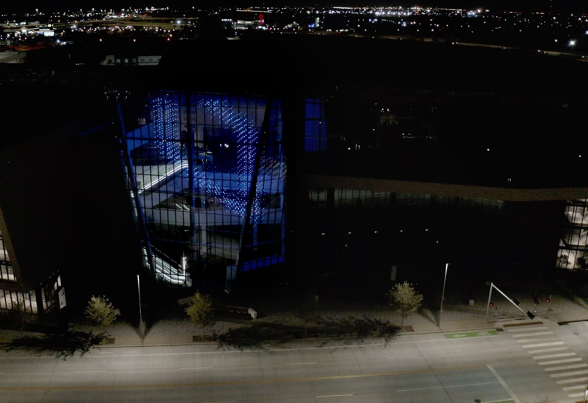 Aerial night view of the convention centre with Virtual Sky glowing blue on its facade