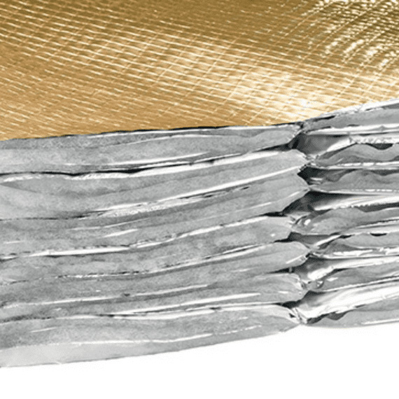 Close-up of silver metallic folded or layered foil sheets with a textured golden surface above.