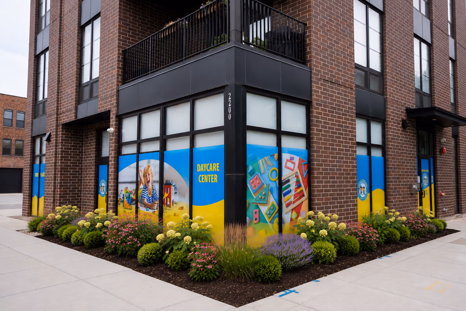 Corner view of a daycare center with colorful window graphics of a child and toys on a brick building.