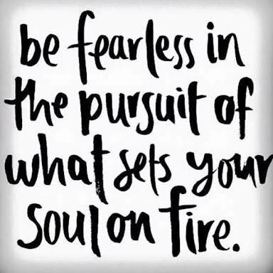 Large illuminated sculpture of a colorful kingfisher bird glowing against a dark night background.