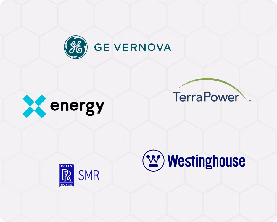 Two male engineers wearing hard hats and work jackets reviewing a tablet outdoors with wind turbines in the background.