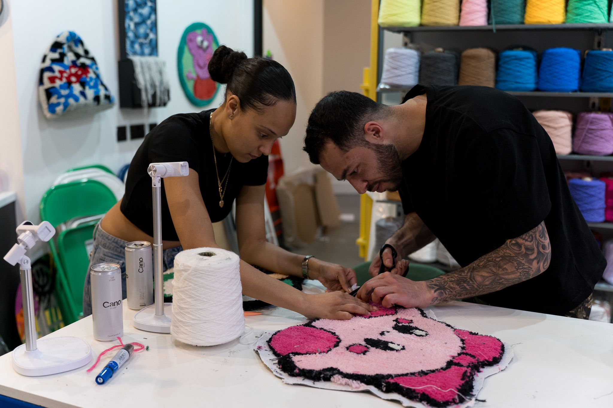 Two participants working together on a pink tufted rug design at Cheeky Studio tufting workshop in Hackney Wick, London