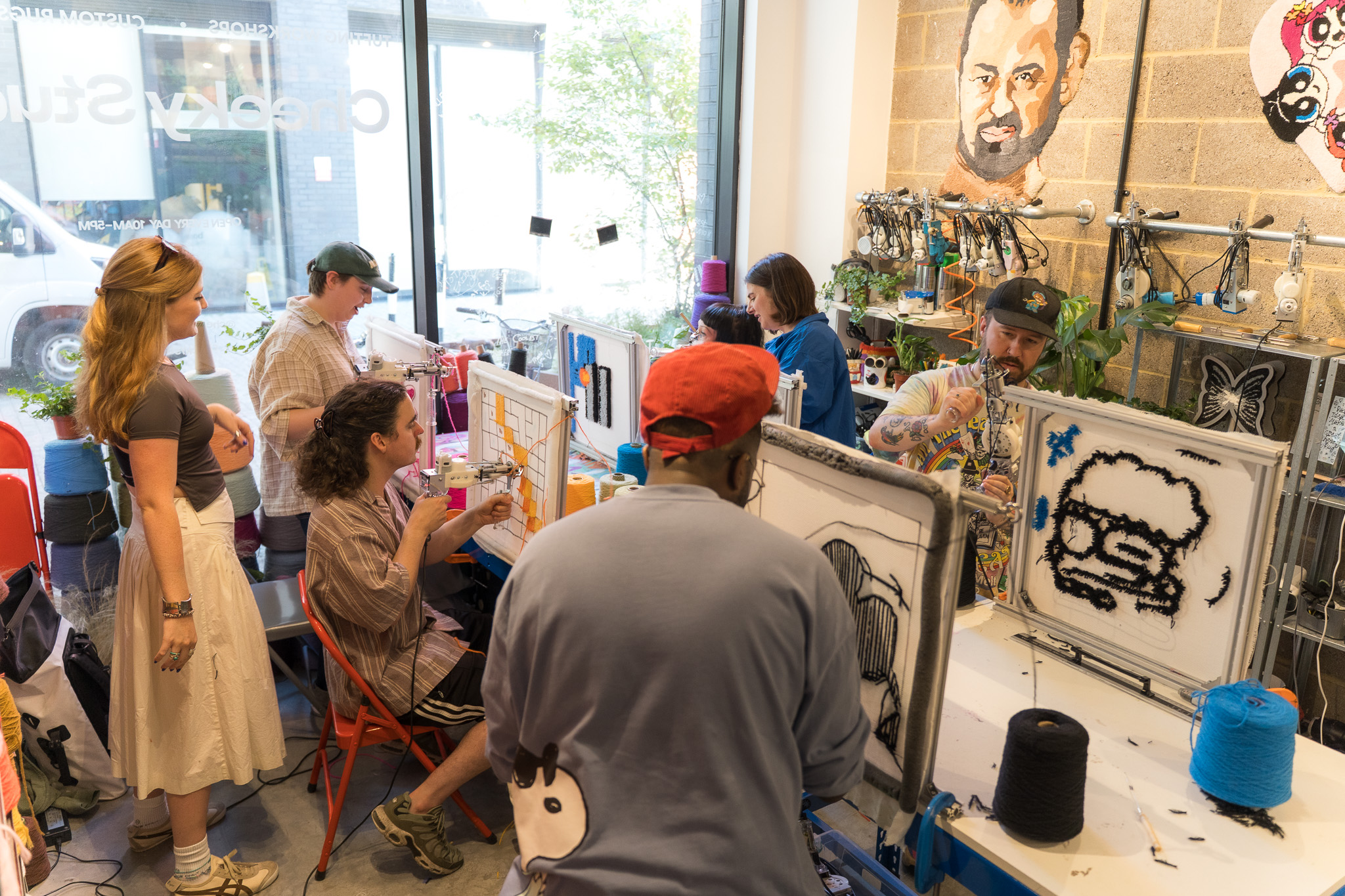 Design team tufting together at a private team building workshop at Cheeky Studio, working at frames along the studio wall