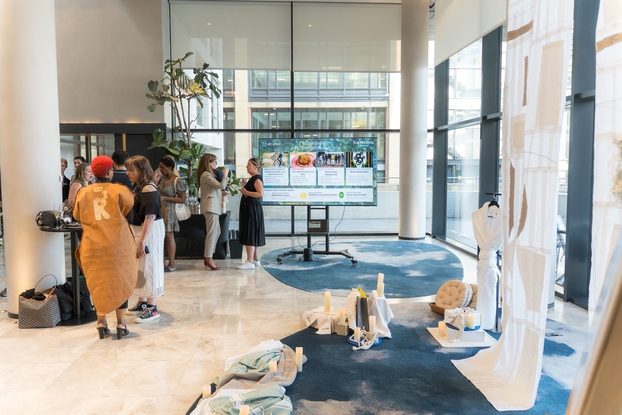 Guests viewing the Threads of Renewal recycled textile installation during an event at The Westin London City