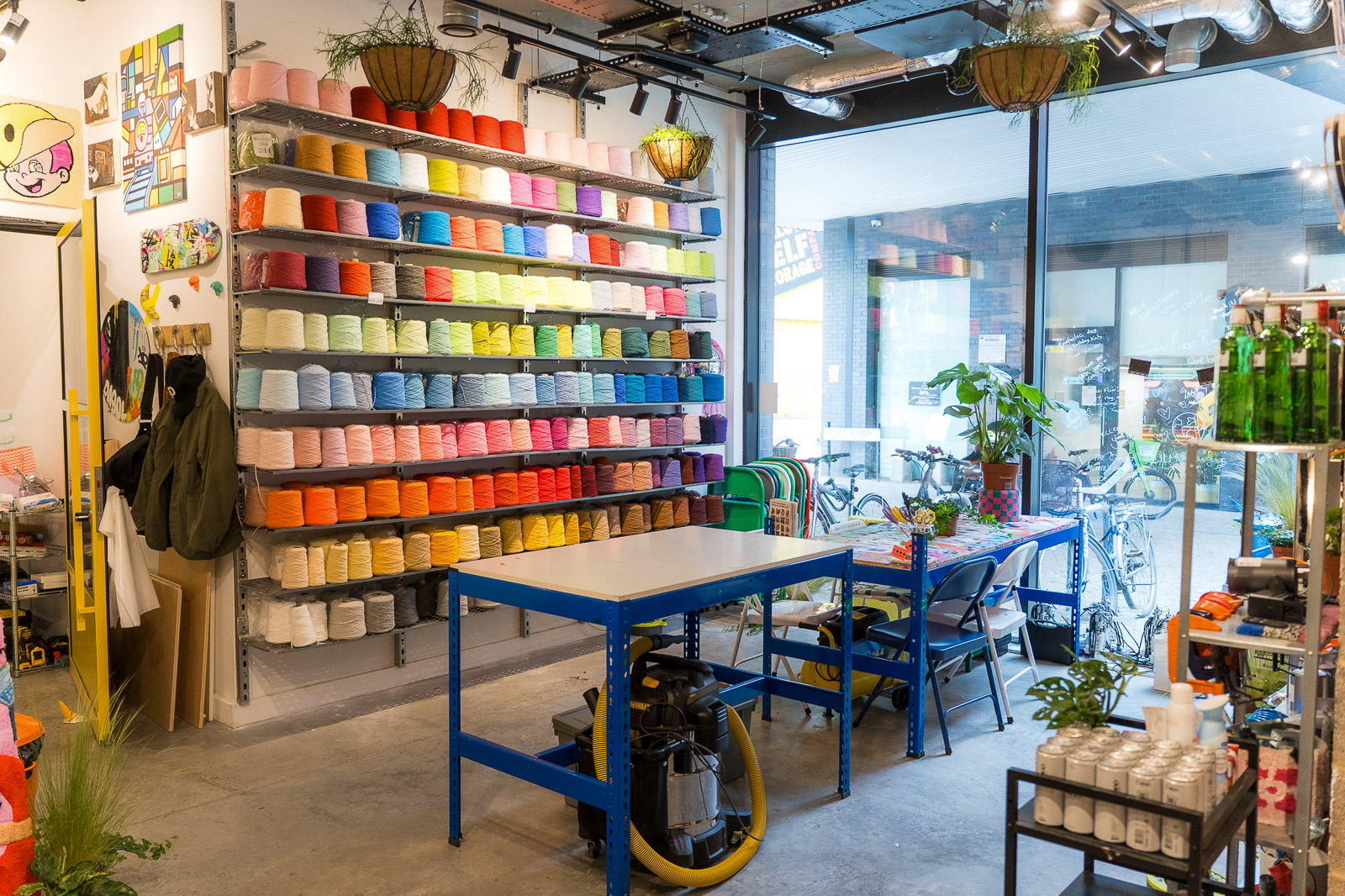 Cheeky Studio self-directed tufting space in Hackney Wick with worktables, tools and a wall of colourful recycled yarn