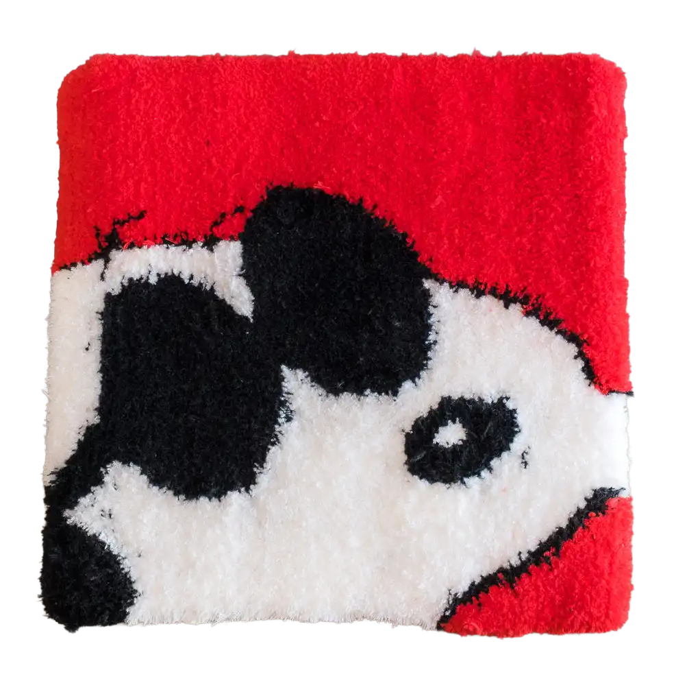 Red square tufted rug featuring a close-up black and white cartoon dog face