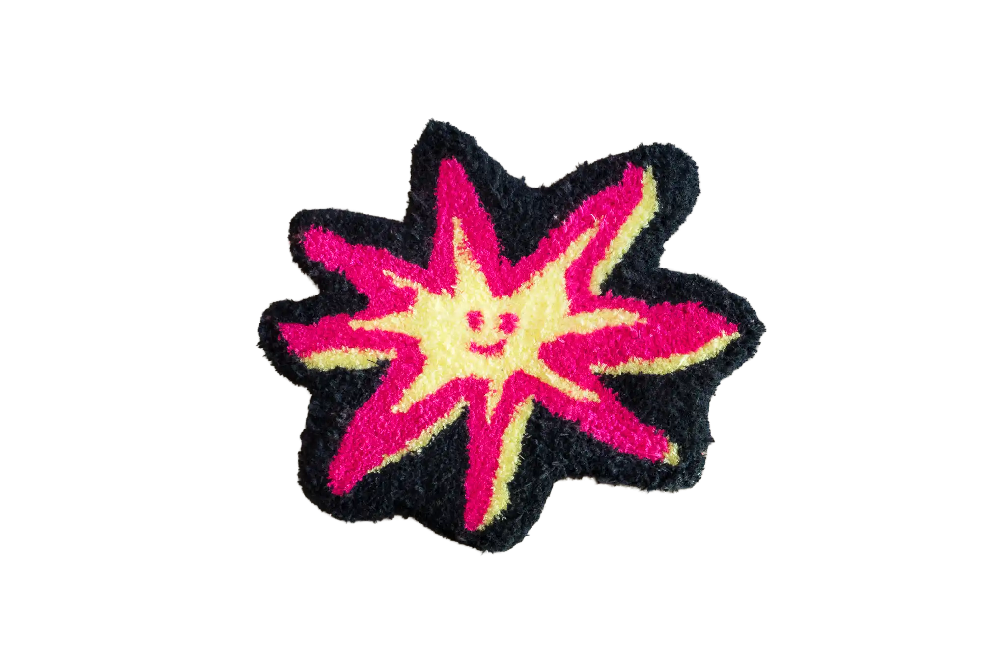 Black starburst-shaped tufted rug with a smiling pale yellow star and vivid pink rays