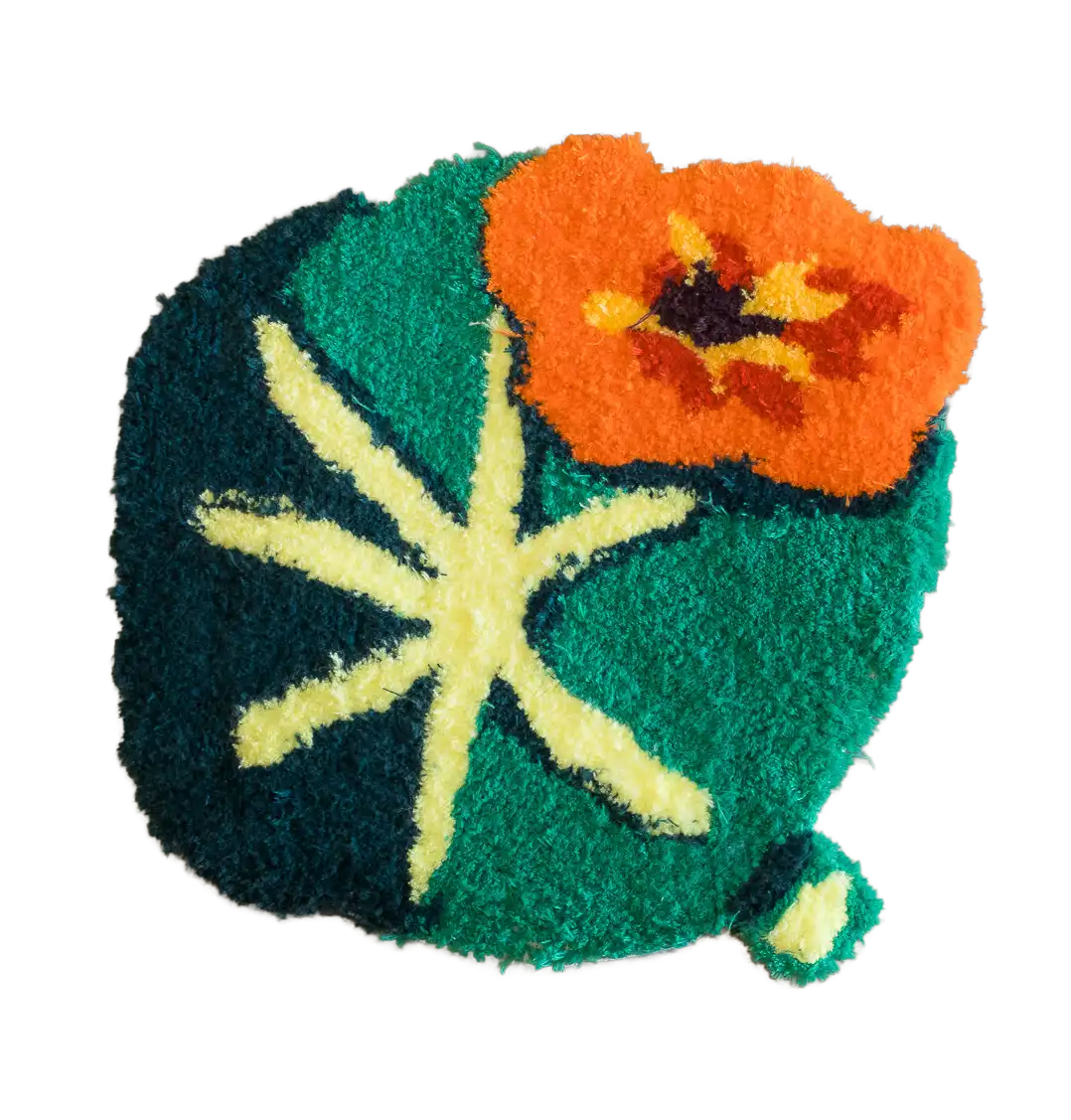 Abstract botanical tufted rug in dark green, turquoise, orange and pale yellow with a large flower