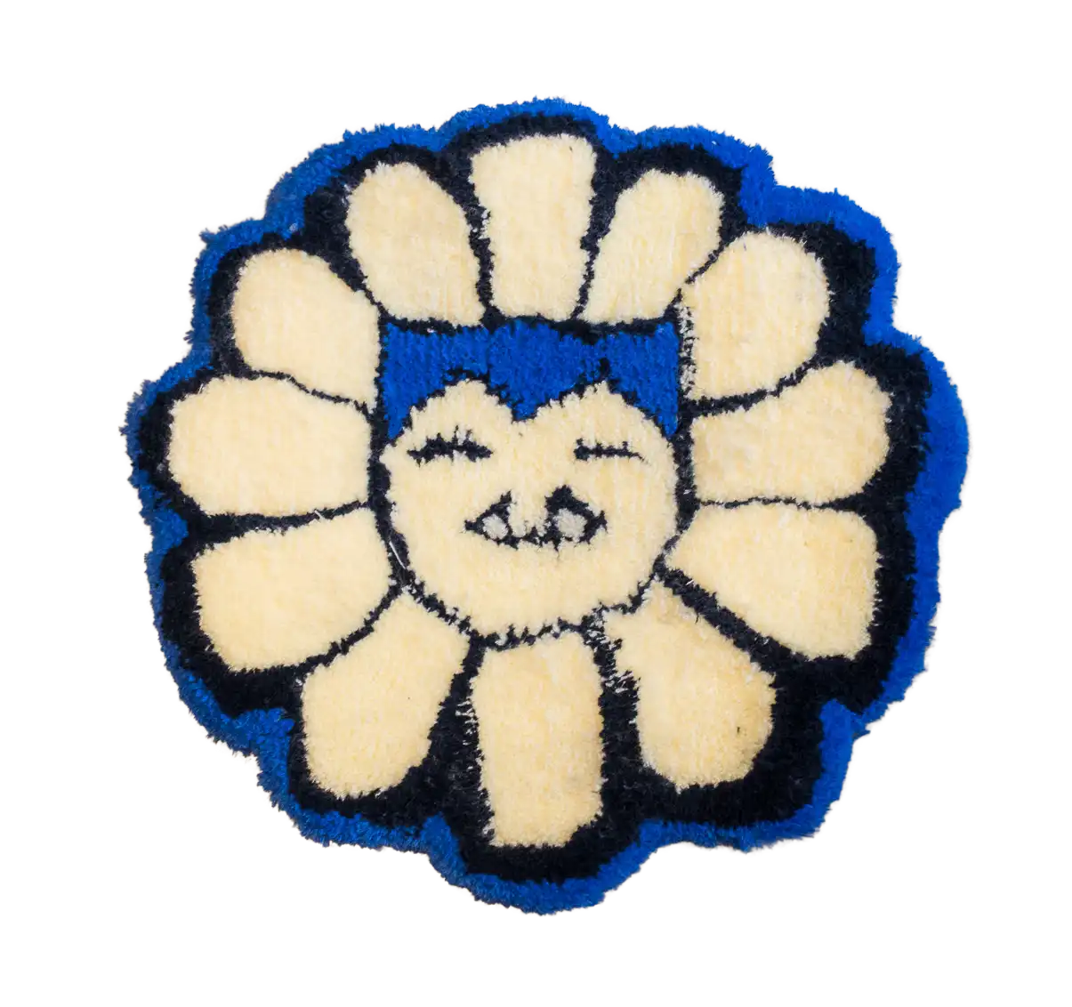 Flower-shaped tufted rug with cream petals, blue edging and a smiling face in the centre