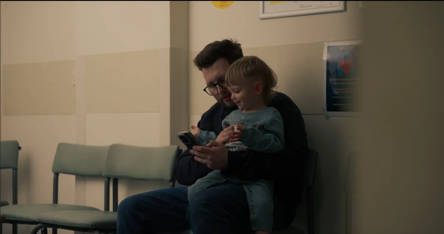 A candid moment of a parent and child sharing a light-hearted interaction, illustrating the authentic human connection that drives social impact stories.