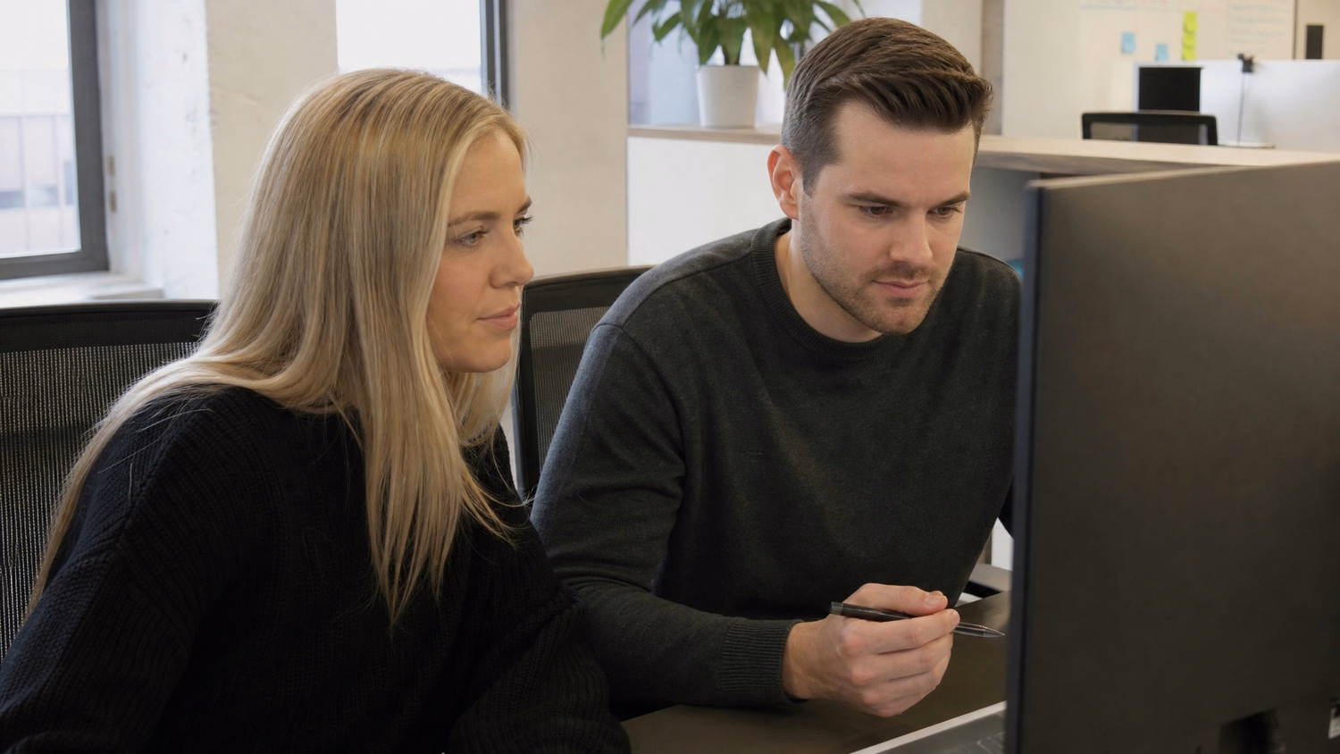 SIDE-BY-SIDE PAIR An IT professional  two people seated side by side reviewin