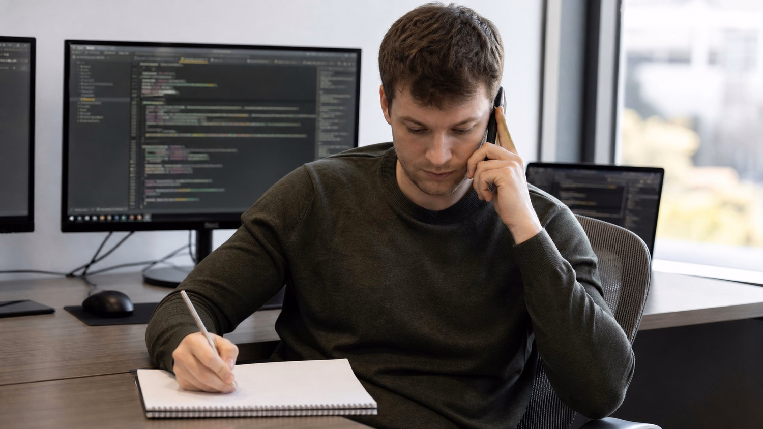 PHONE CALL AT DESK An IT professional  one person at a desk with phone to one