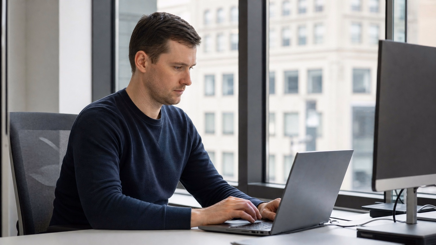 WINDOW SEAT LAPTOP An IT professional  one person working on a laptop at a de