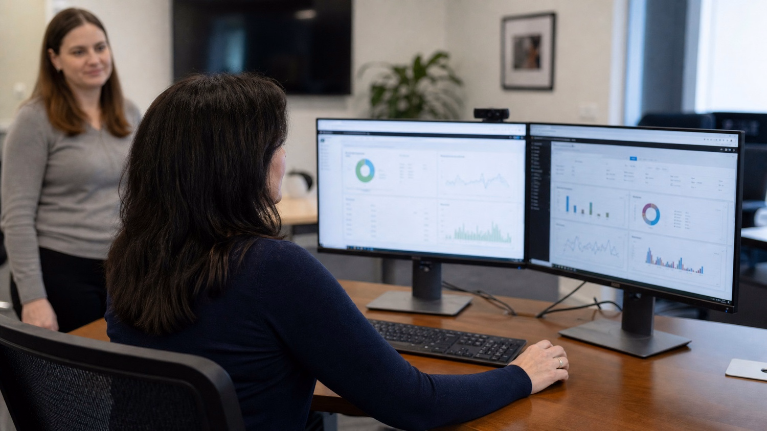 Network admin analyzing dual monitor data charts