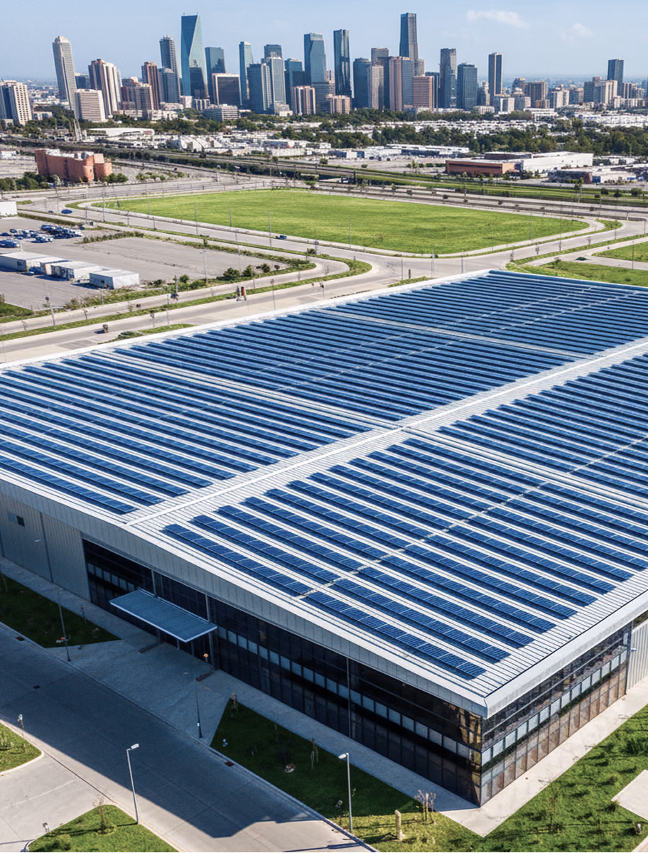 A sunny, wide-angle drone shot of a New Jersey community solar farm: rows of ground-mount panels stretching across a former brownfield, with a “Community Solar – Open to All NJ Residents” banner in the foreground and the Newark skyline on the horizon.