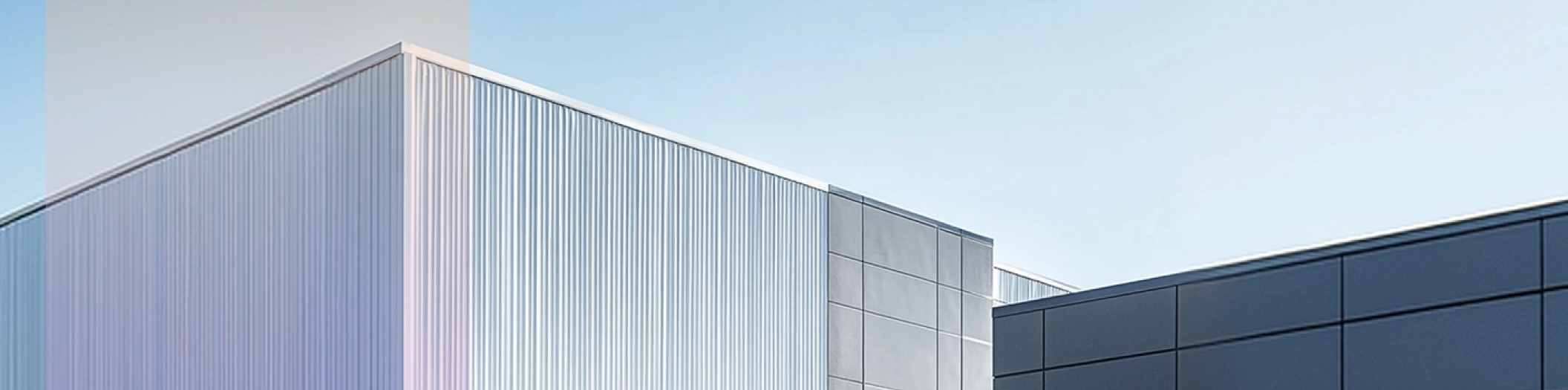 battey storage containers lined up on a large concrete surface under a clear blue sky.