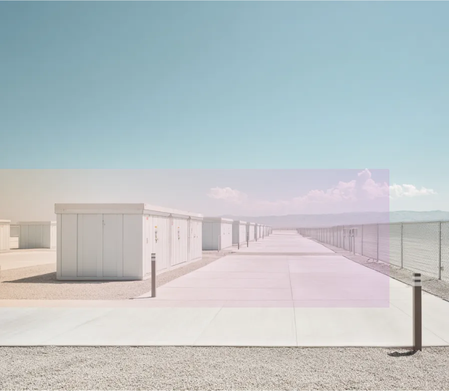battey storage containers lined up on a large concrete surface under a clear blue sky.