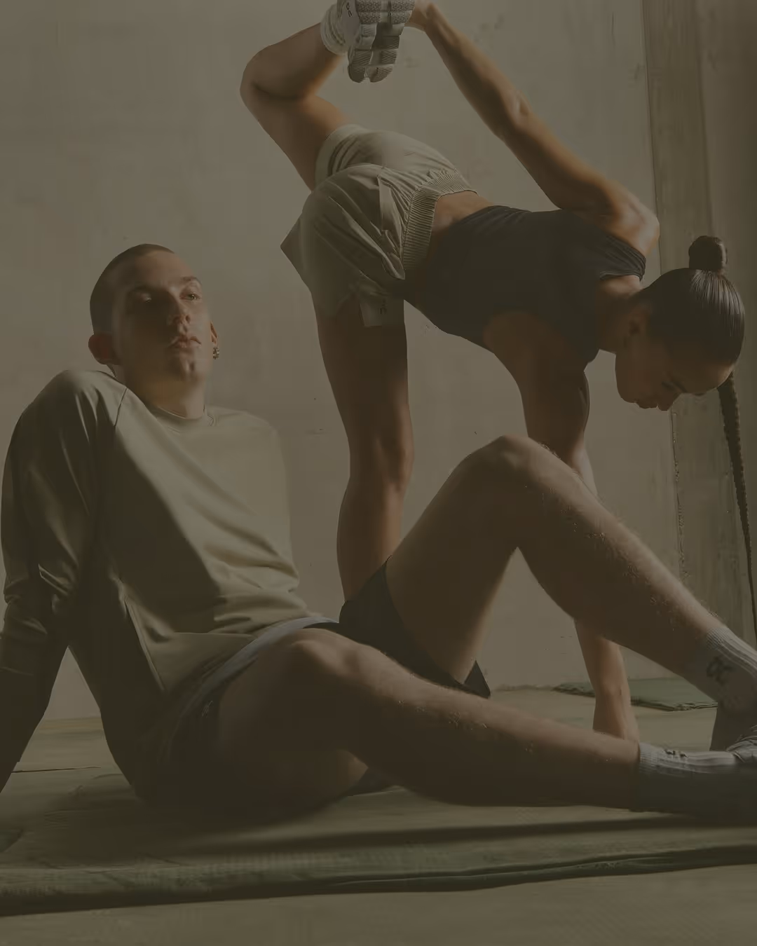 Coach helping a client stretch on a mat