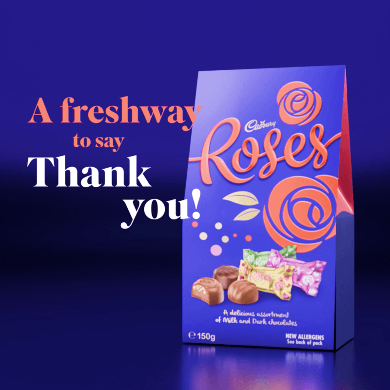 Cadbury Roses chocolate box with decorative roses and the text 'A fresh way to say Thank you!' in orange and white on a purple background.