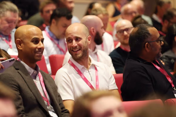 Two attendees in a theatre chatting