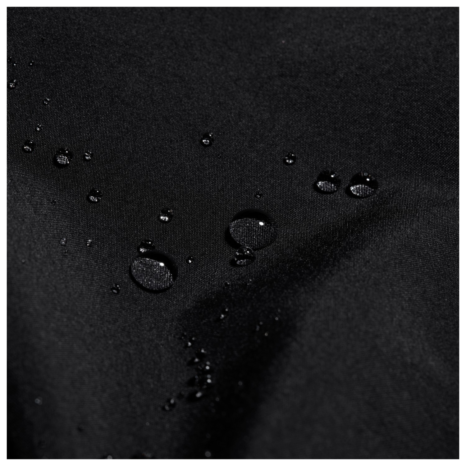 Close-up of water droplets beaded on black water-resistant fabric.