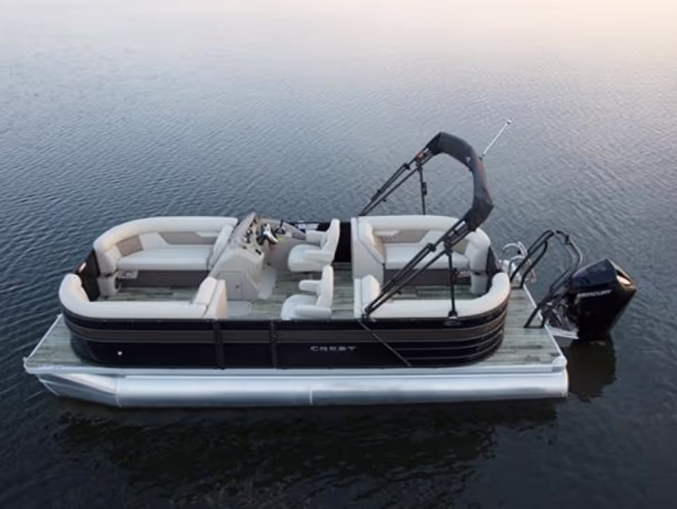 2021 Crest Classic pontoon boat with cushioned seating and a motor floating on calm water.