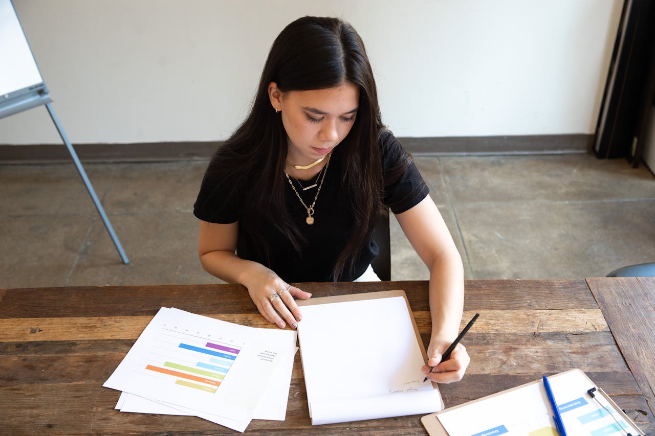 Martial artist  analyzing budget charts and financial data at a desk, representing the hidden cost analysis dojo owners should perform