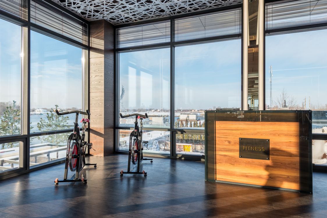A sunlit studio corner with floor-to-ceiling windows and a wooden reception desk