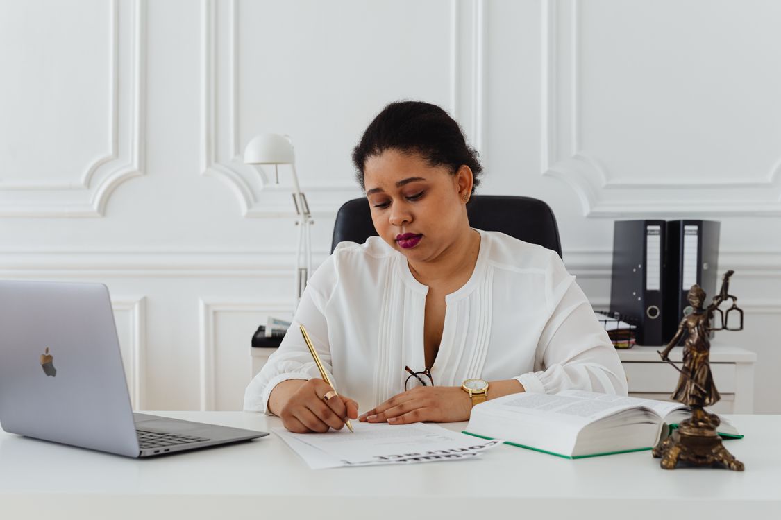 A woman signs a membership agreement at an office desk before recurring billing starts
