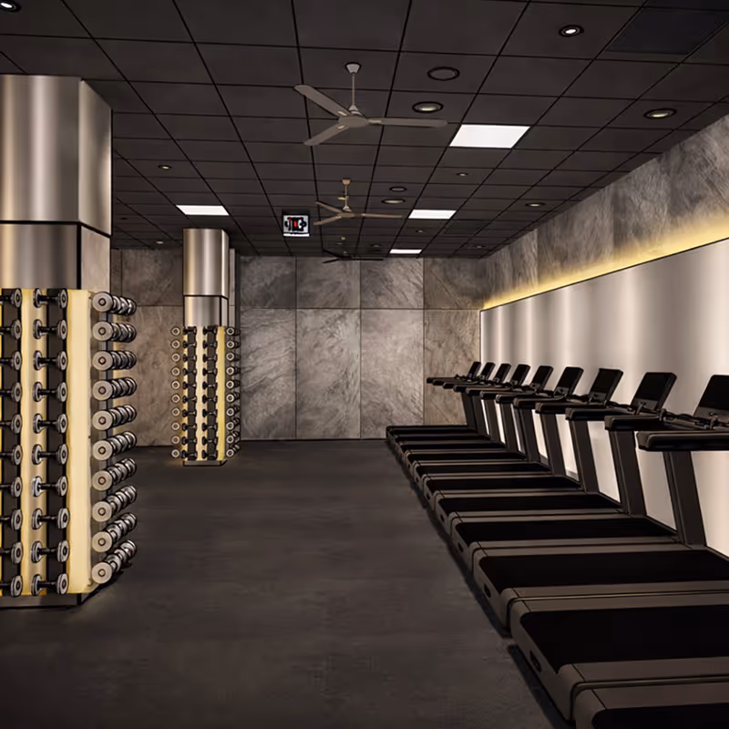 Nowoczesna siłownia z rzędem bieżni po prawej i stojakami z hantlami po lewej stronie.